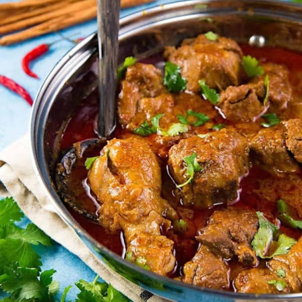 Close-up of Sherpa Indian Kitchen's chicken curry in a pan, garnished with fresh cilantro.